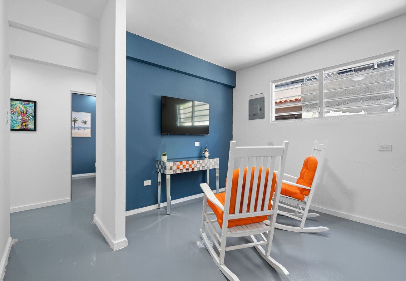 Living area with rocking chairs & smart TV – Condado 1BR