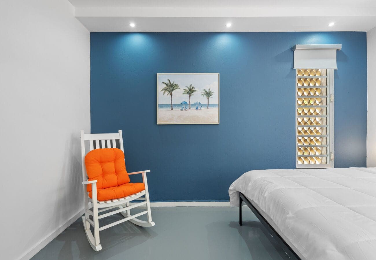 Queen bedroom with palm art & room-darkening shades