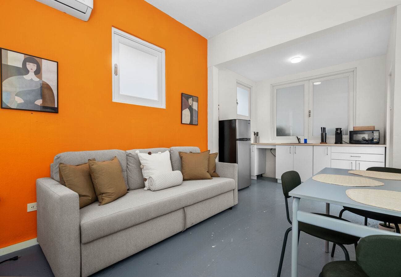 Cozy sofa bed with bold orange accent wall