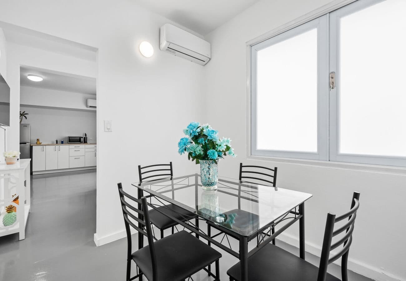 Glass dining table for four with fresh flowers