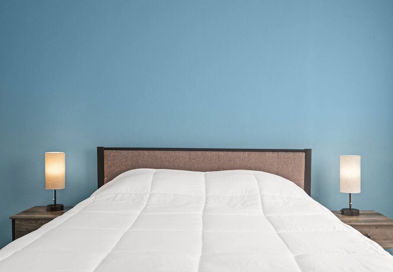 Queen bed with bedside lamps and natural light