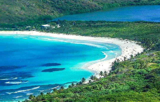 Una impresionante playa tropical con arena blanca, aguas turquesa y un cielo azul despejado.