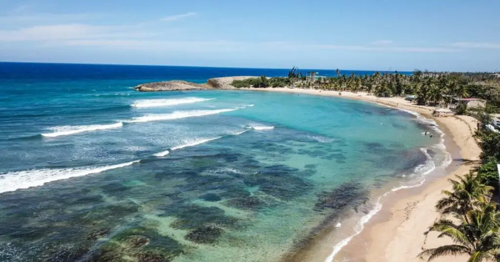 La playa es una hermosa franja de arena dorada que contrasta con las aguas azules y cristalinas. Los surfistas encontrarán olas desafiantes, mientras que las familias pueden disfrutar de zonas más calmas para nadar y tomar el sol.